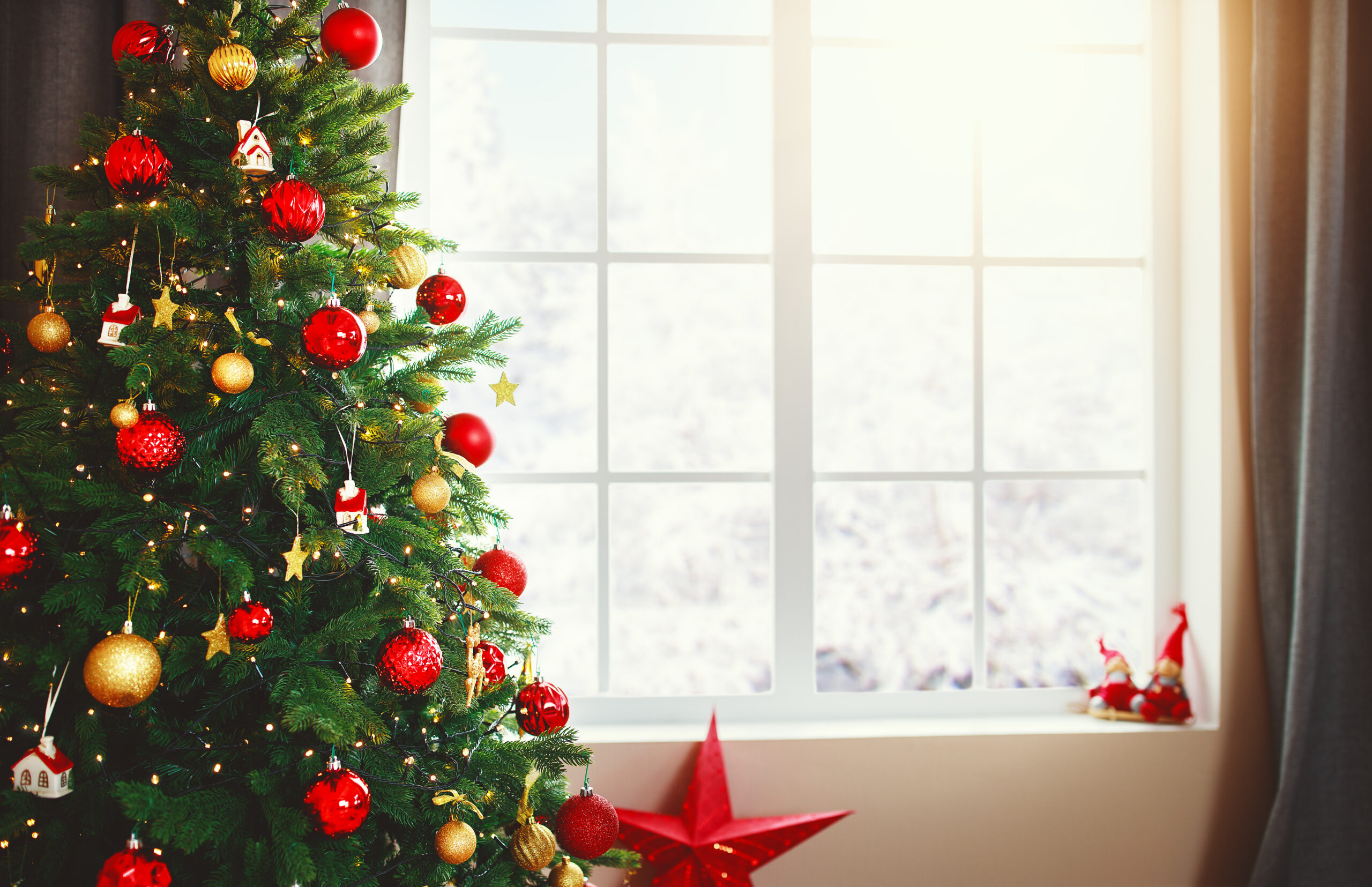 Christmas interior tree with gifts near the window at home